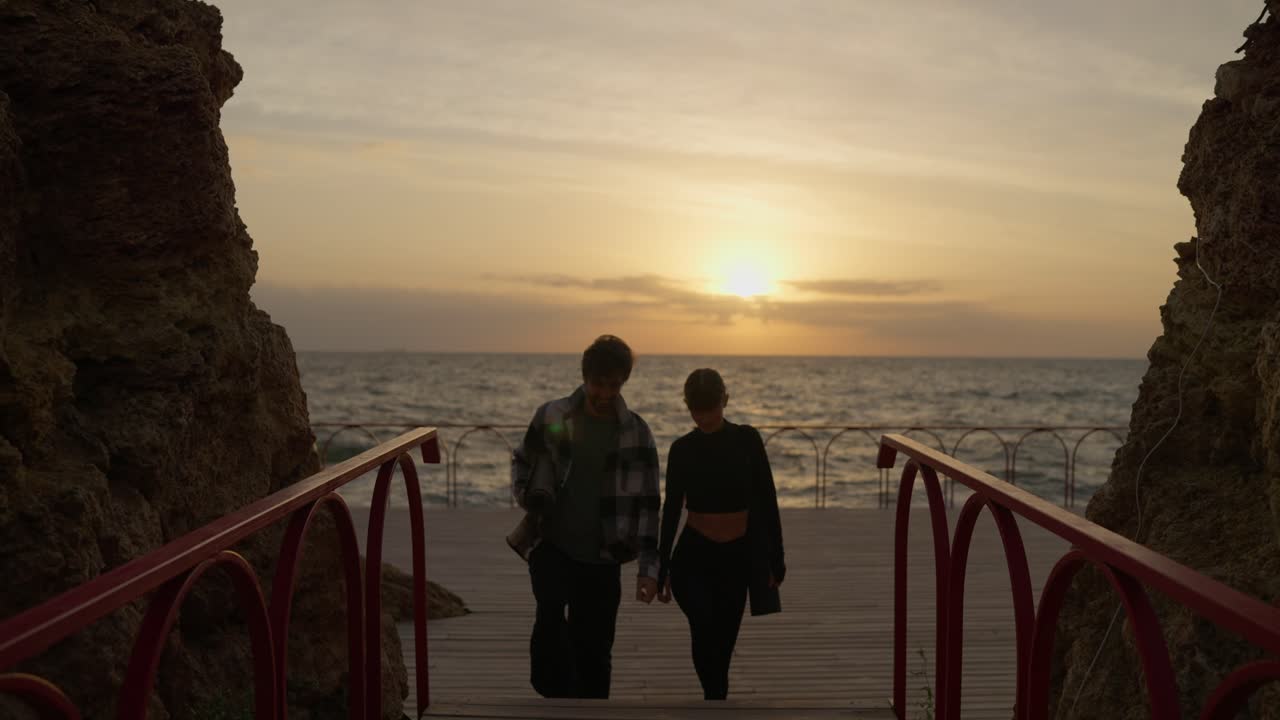 요가 를 즐기는 커플 이 해가 뜨면 해변 다리 에서 산책 하고 있다
