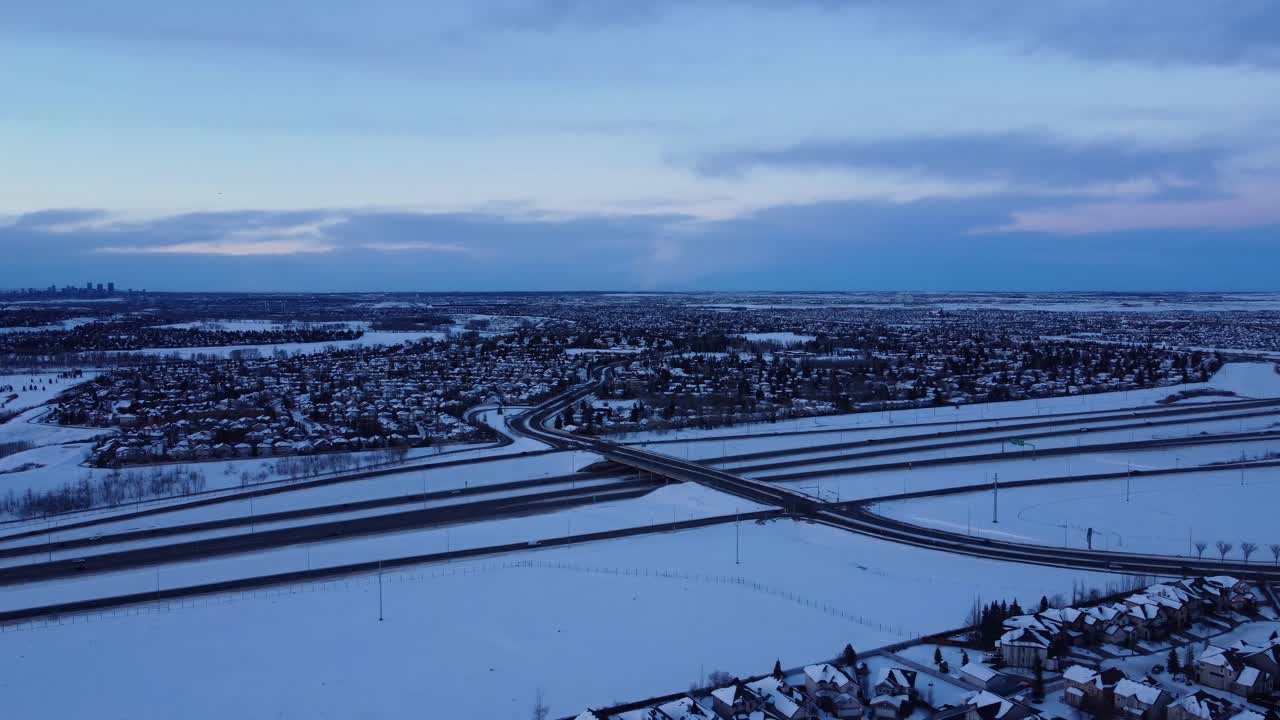 Questo Suggestivo Filmato Mostra una Comunità Invernale Nelle Ore Crepuscolari, con Tetti Innevati e Strade Gelate