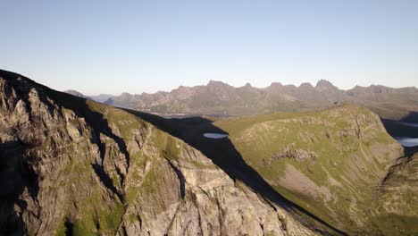 cinematic shot of high rise green mountains kvalvika beach, lofoten, norway