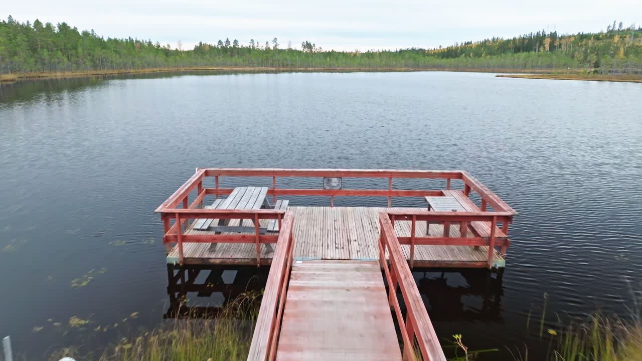 Wooden Boardwalk To The Dock With Picnic Tables By The Lake Surrounded By Forest In Sweden