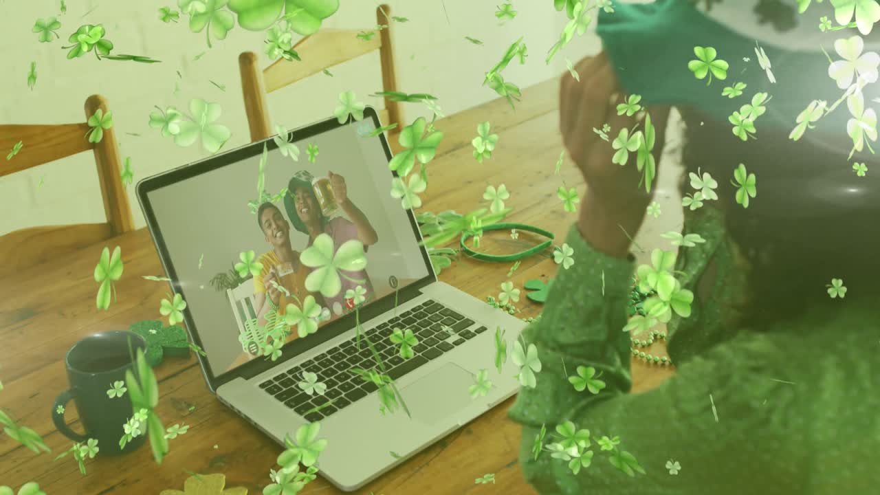 hojas de trébol cayendo contra la mujer que lleva gafas de trébol mientras tiene una videollamada en casa