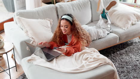 young woman relaxing on couch, shopping online