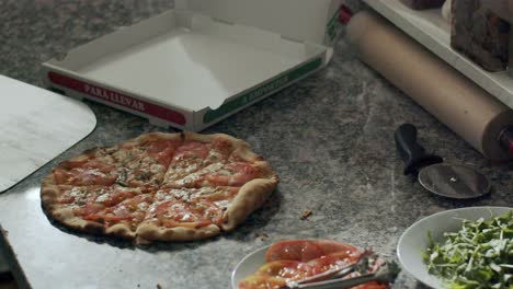 Cook-preparing-pizza-for-delivery-on-kitchen