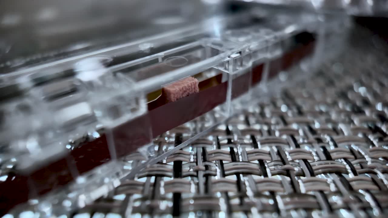 Macro view of a clear cassette tape housing with red reel, capturing retro tech and music nostalgia