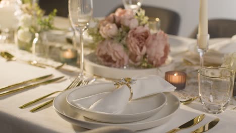 Close Up Of Person Arranging Table Setting For Meal At Wedding Reception