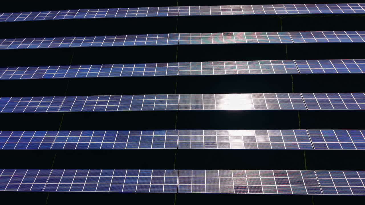 File di pannelli solari catturano la luce solare in un impianto di energia rinnovabile durante il giorno.
