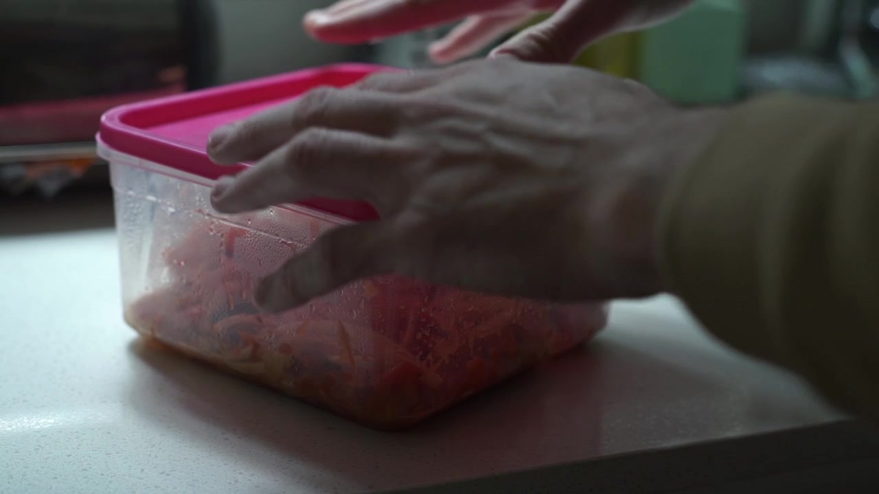 Covering lid of plastic food box on kitchen counter