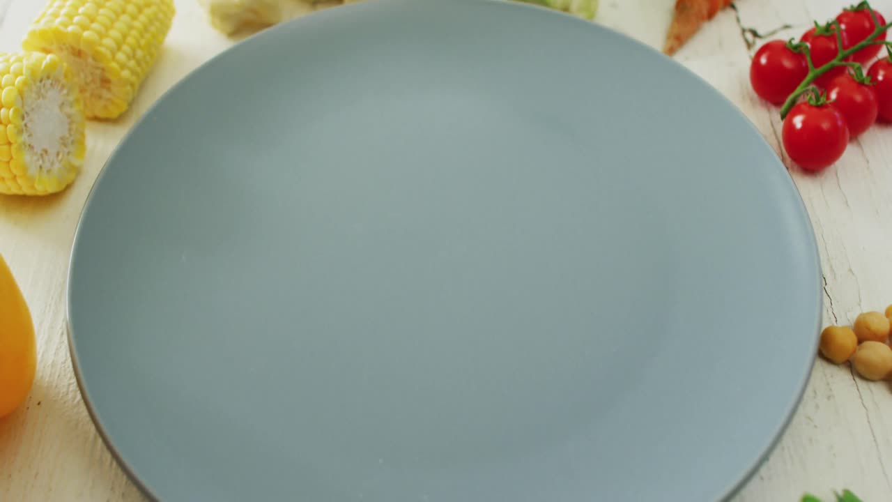 ⁇ 색 시골 배경에 복사 공간과 함께 회색 접시 주위에 배열 된 신선한 채소의 비디오