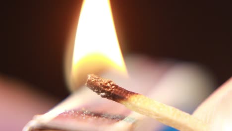 lighting a match from matchbox on black background