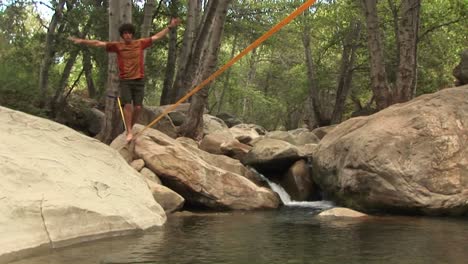 jibup de un joven slackline a través de un plácido agujero de natación