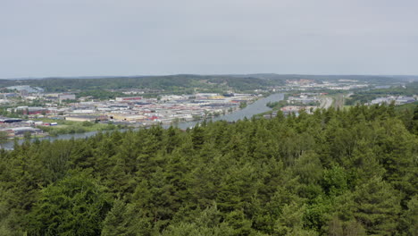 Hill-with-tree-forest-revealing-harbour-work-office-industrial-buildings-area-neighbourhood-river-warehouses-truck-delivery-Gothenburg-moody-nordic-transportation-Scandinavian-shipping-company-post