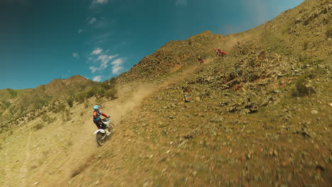 mountain slopes become challenging racetrack fpv drone. professional motocross competitors throttle bikes vying for lead in high-altitude contest