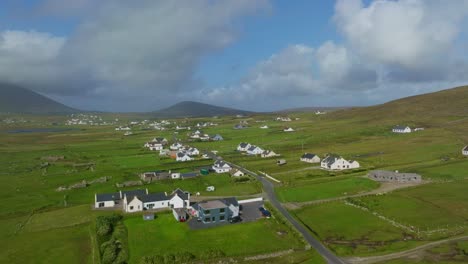 Drone-shot-of-a-small-village-between-lush-green-fields-on-Achill-island