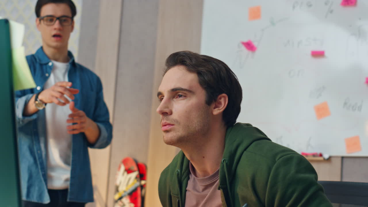 hombre de aspecto serio computadora hablando colega primer plano. freelancers discutiendo