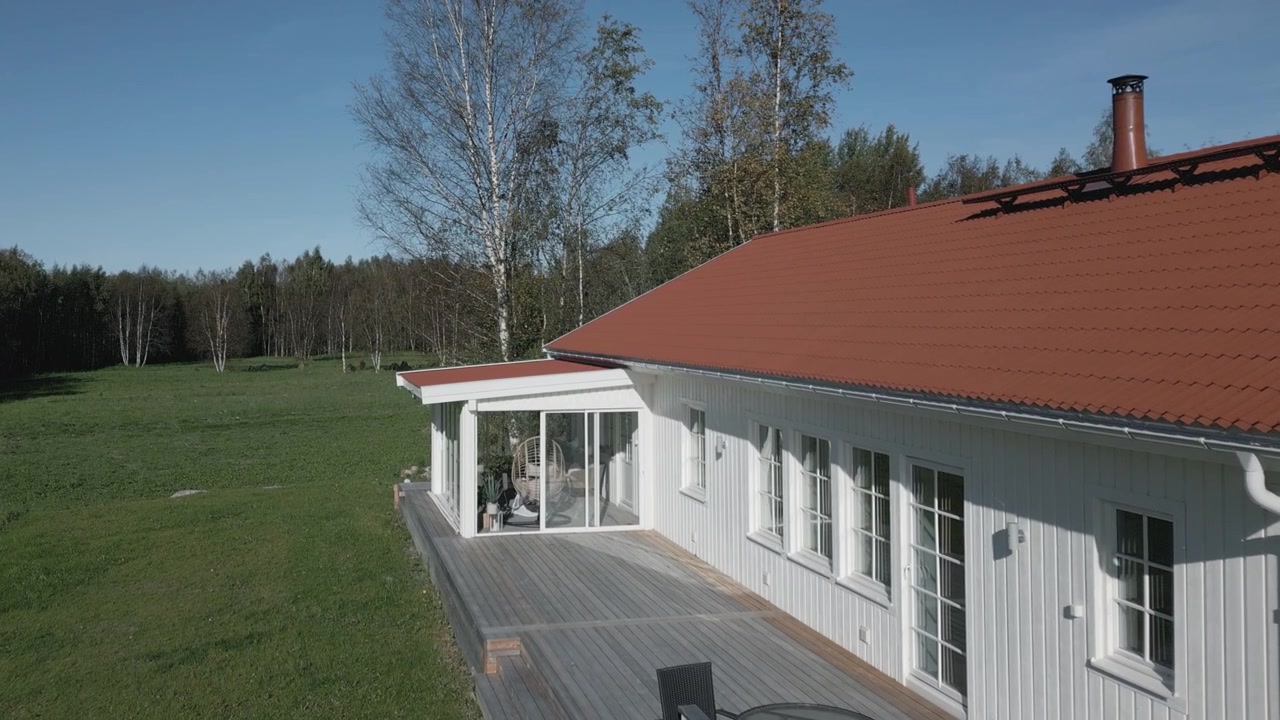 Typisk nordisk villa med glaspergola og terrasse på landet i Skandinavien