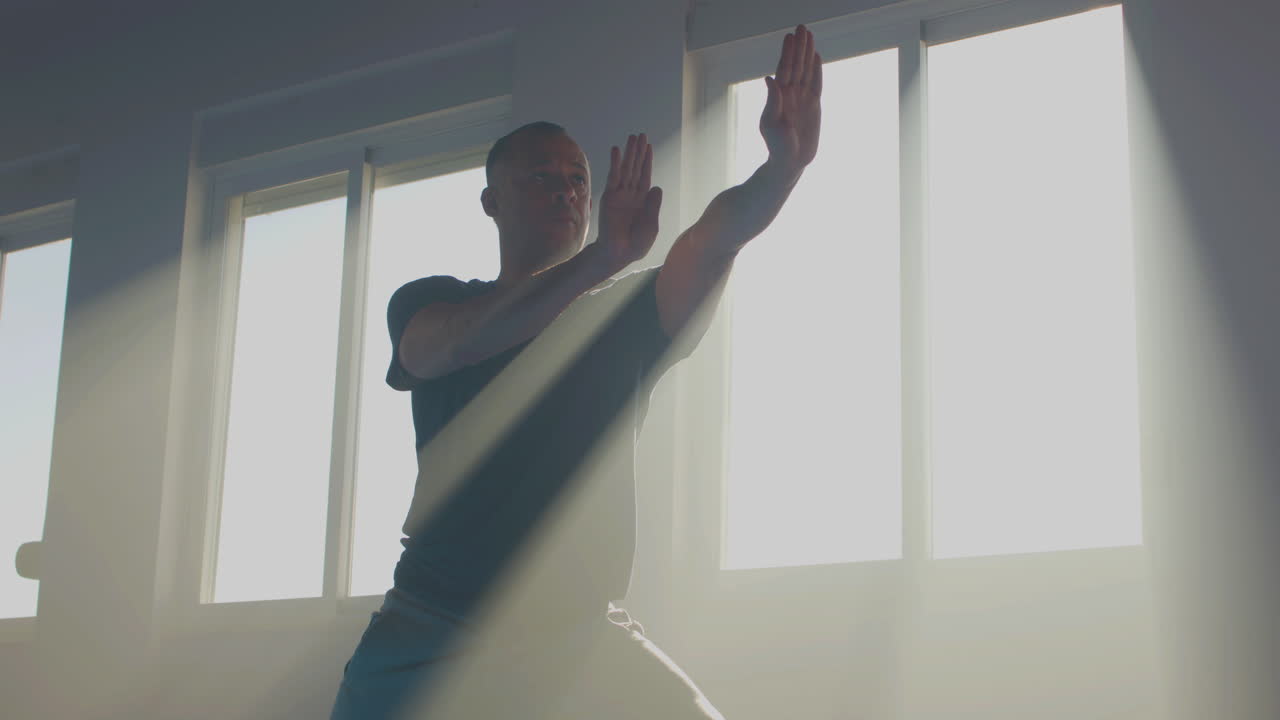 hombre enfocado realizando movimientos lentos de las manos en el gimnasio