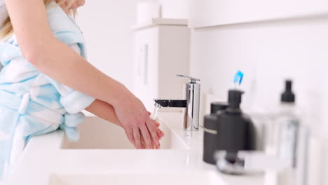 mother helping child wash hands