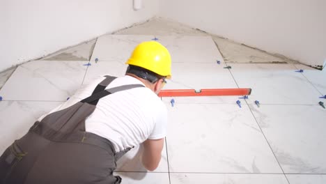 the tiler installs tiles on the floor repairing the interior of the house
