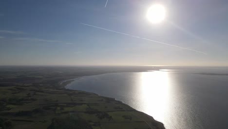 aerial view of the incredible beautiful coastline with sun and blue sky in odsherred, zealand, denmark