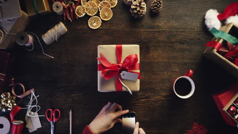 Vista-Superior-De-Las-Manos-Usando-La-Tableta-Del-Teléfono-Inteligente-Con-Pantalla-Táctil-Mesa-De-Regalos-De-Navidad-Desde-Arriba---Dragón-épico-Rojo