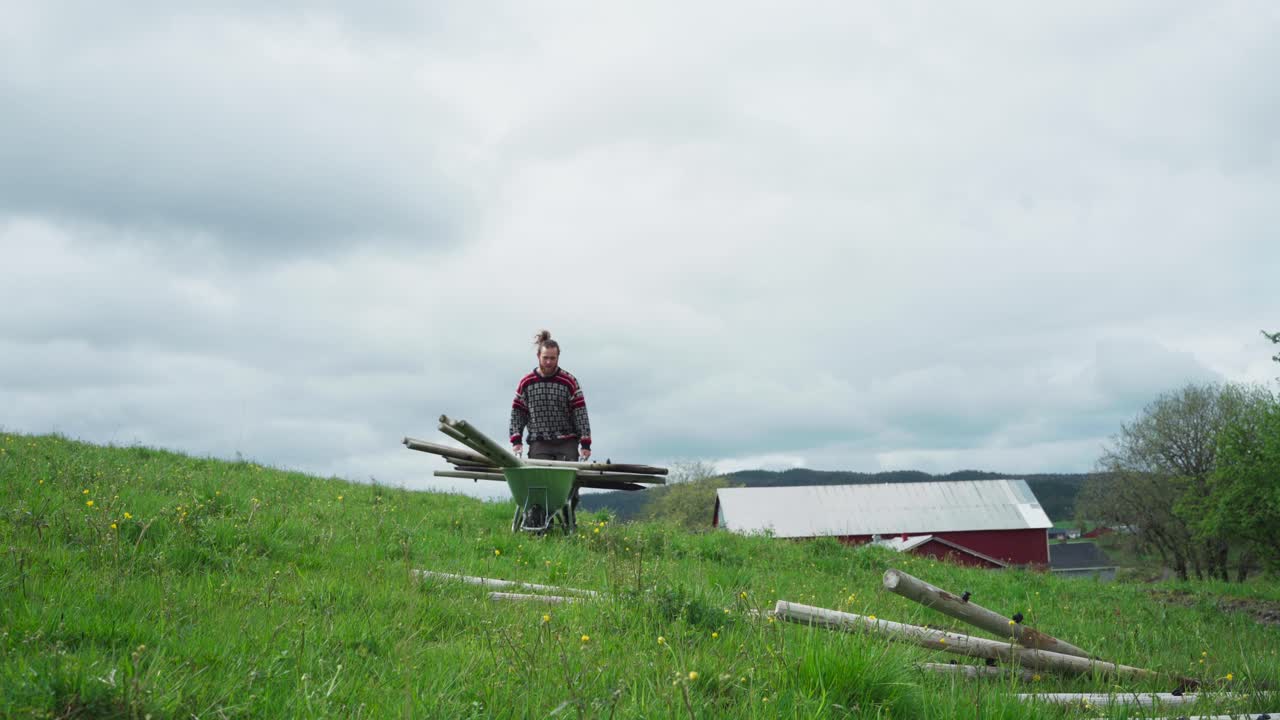 푸른  ⁇  에 있는 사람 은 울타리 를 세우는 기둥 을 세우고 있다