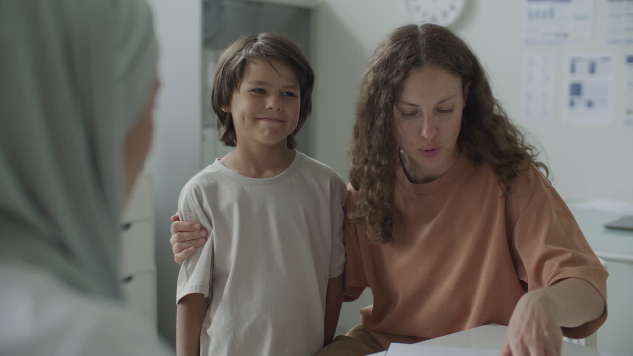 Mother of Young Boy Consulting with Doctor during Pediatric Clinic Visit