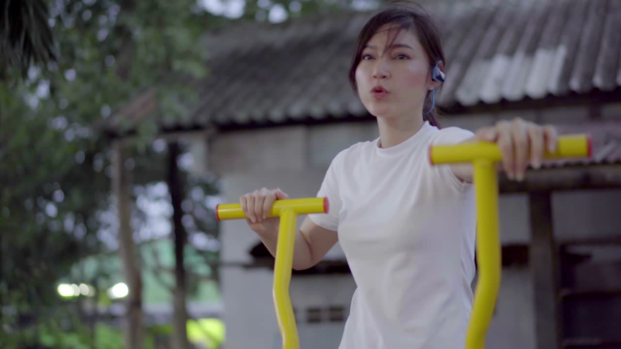 공원에서 타원형 기 트레이너 피트니스 기계에서 운동하는 여성