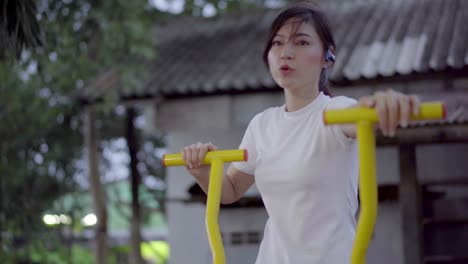 mujer haciendo ejercicio en un entrenador de caminata elíptica en una máquina de fitness en el parque