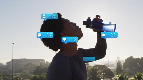 Animation-of-notification-icons-and-numbers-over-african-american-man-drinking-water-against-sky