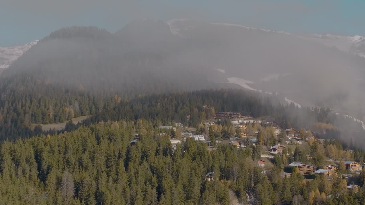 antena cinematográfica sobre el hermoso resort suizo con bosques de pinos verdes y exuberantes en las montañas suizas, suiza
