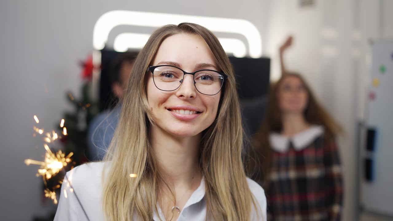 joven mujer de negocios en una fiesta de la empresa con un palo brillante, sonriendo a la cámara