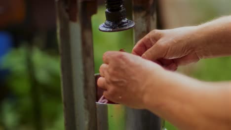 An-elderly-man-making-apple-juice-in-a-juice-machine-in-the-countryside