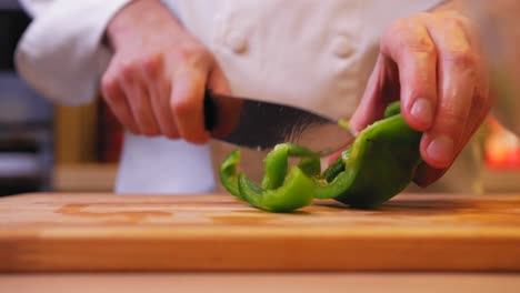 the-cook-cuts-the-green-pepper-on-a-wooden-board