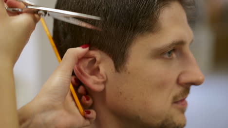 varón caucásico adulto con corte de pelo en el salón, cierre de tijeras para cortar el pelo