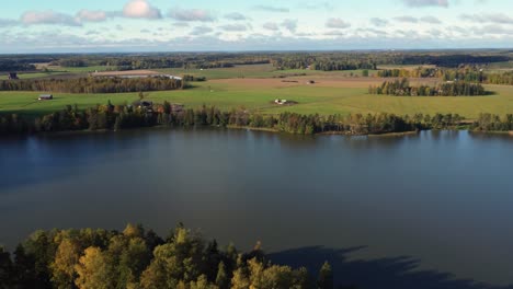 flyover northern lake amid bucolic farm house properties in finland