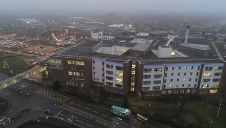 aerial view british nhs hospital on misty wet damp morning rising above rooftop