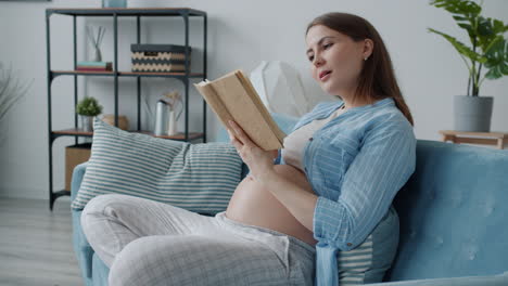 pregnant woman reading on sofa