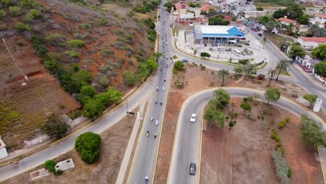 Aerial-top-down-Rising-shot-of-many-motorbikes-driving-on-road-in-Pampatar-during-distinguished-gentleman's-ride-2024