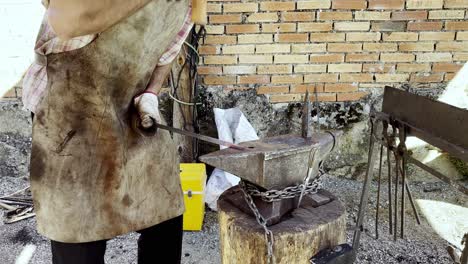 blacksmith hammers with great strength to form metal into workable shape at ethnographic festival lonoa