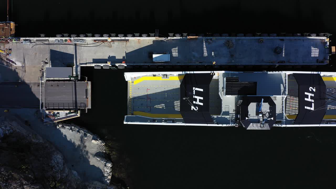 Ferry Hydra slowly approaching Nesvik ferry pier Norway - Static birdseye aerial watching ferry approaching last meters -