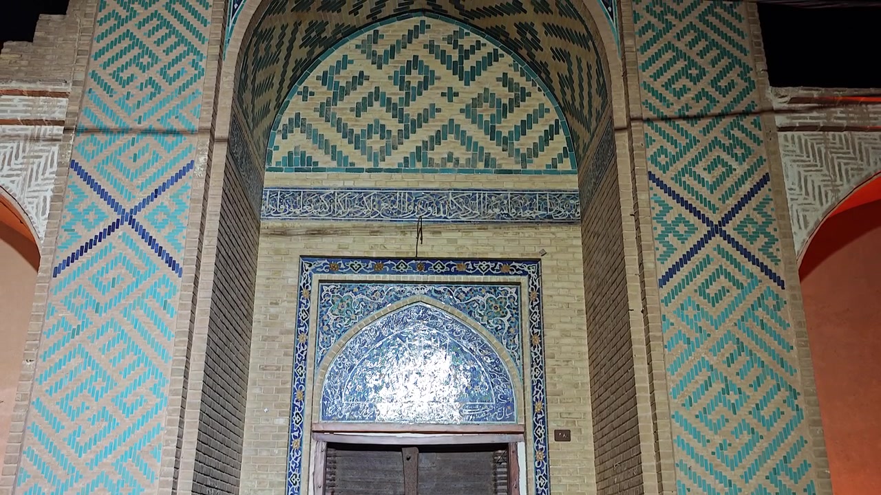 Ingresso ornato di un'antica moschea con intricate piastrelle.
