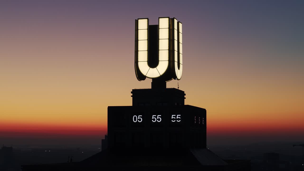 Dortmund U illuminated, and city skyline silhouette at sunrise, close up drone orbit