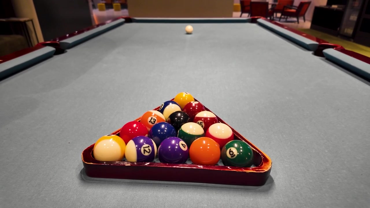 Close-up of billiard rack zooming out to a pool table in a cozy room