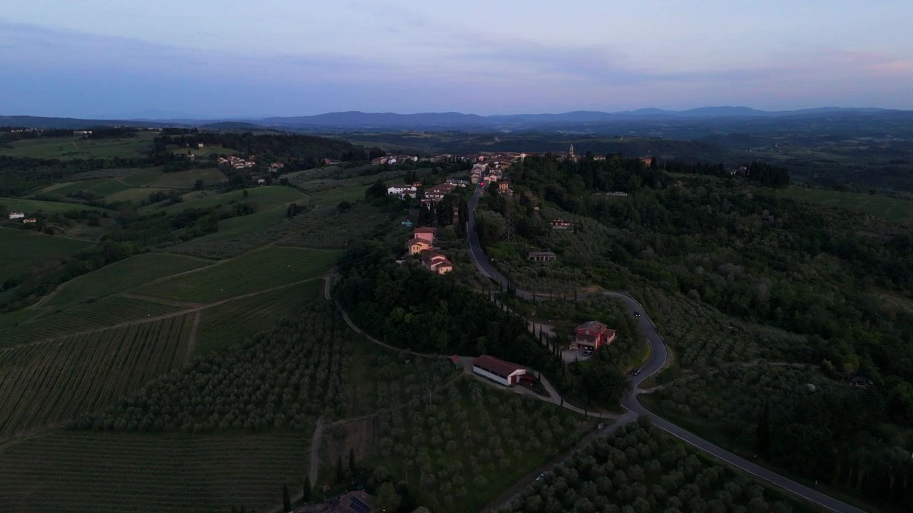 Ripresa aerea con drone che si avvicina al villaggio di Marcialla in Toscana al crepuscolo