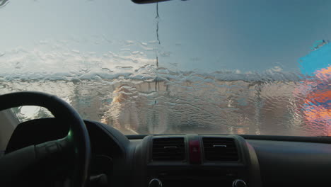 a woman washes her car in a self-service sink