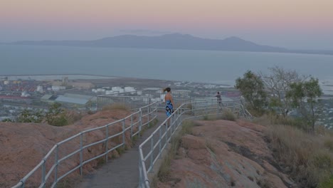 lady wearing blue dress on hilltop viewpoint at castle hill lookout in townsville, queensland, australia