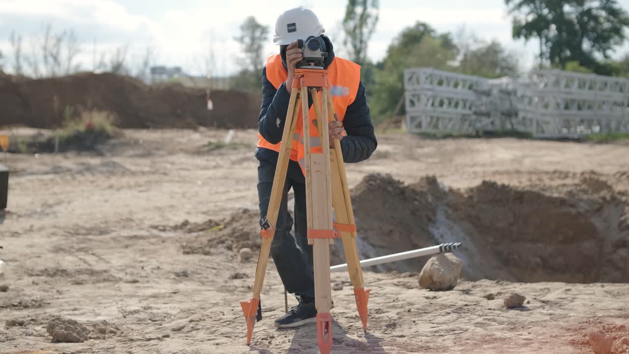 un ingeniero topógrafo toma mediciones en la construcción de una subestación de transformador