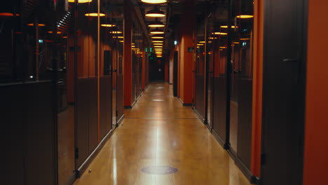 modern office hallway with orange walls and glass offices