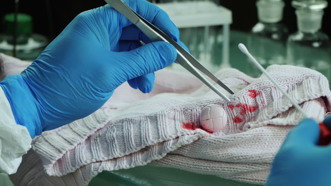 trabajador de laboratorio criminal examina evidencia en ropa 3