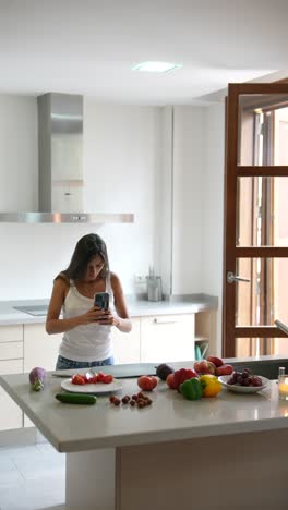 woman taking pictures of healthy food in a kitchen